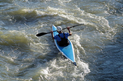 A male kayaker with helmet seen from above