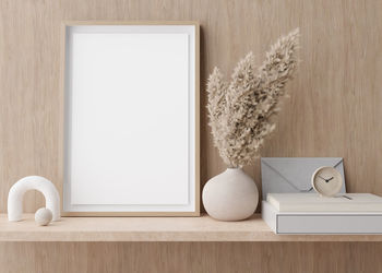 Empty vertical picture frame standing on shelve in modern room. mock up interior 