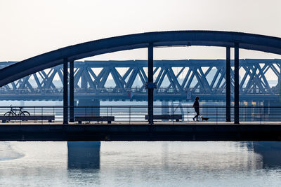 Full length of woman walking on footbridge over river