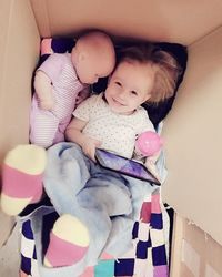 High angle view of baby and child in box