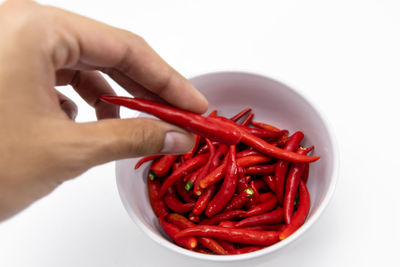Midsection of red chili pepper against white background