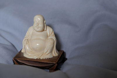 Close-up of buddha statue on bed