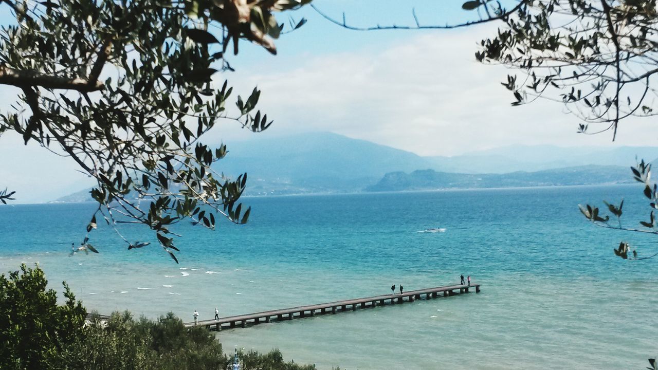 mountain, water, sea, scenics, sky, tranquil scene, tranquility, beauty in nature, tree, blue, mountain range, nature, horizon over water, branch, idyllic, cloud, cloud - sky, day, outdoors, non-urban scene