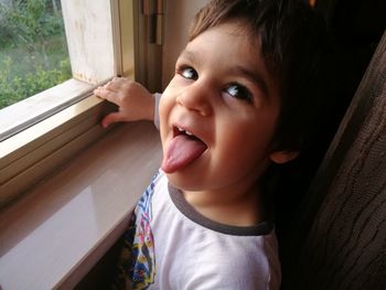 High angle view of boy standing by window at home