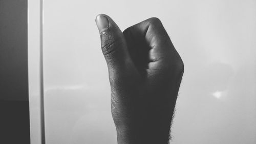 Cropped image of human hand against metal