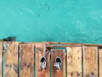 Low section of person standing by swimming pool