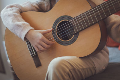 Little girl plays the guitar.