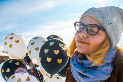 Close-up of smiling woman holding balloons