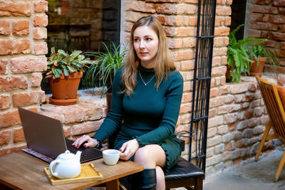 Woman using laptop while sitting at cafe