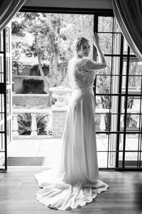 Rear view of young woman standing at home