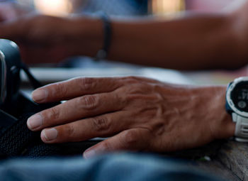 Close-up of man holding hands on table