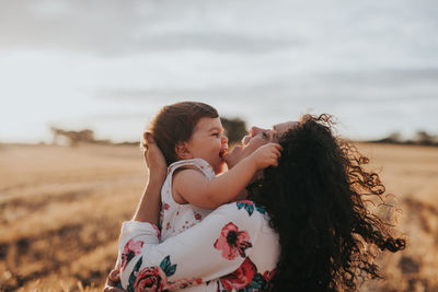 Mother and daughter against sky