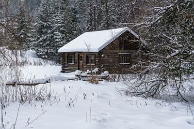 An old log cabin during winter snowfall in wakefield, quebec, canada