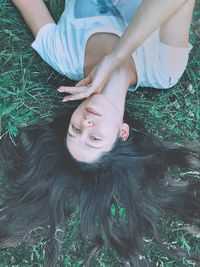 High angle portrait of woman lying on grass