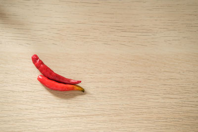 High angle view of red chili peppers on hardwood floor