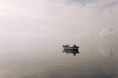 Man in boat on sea against sky