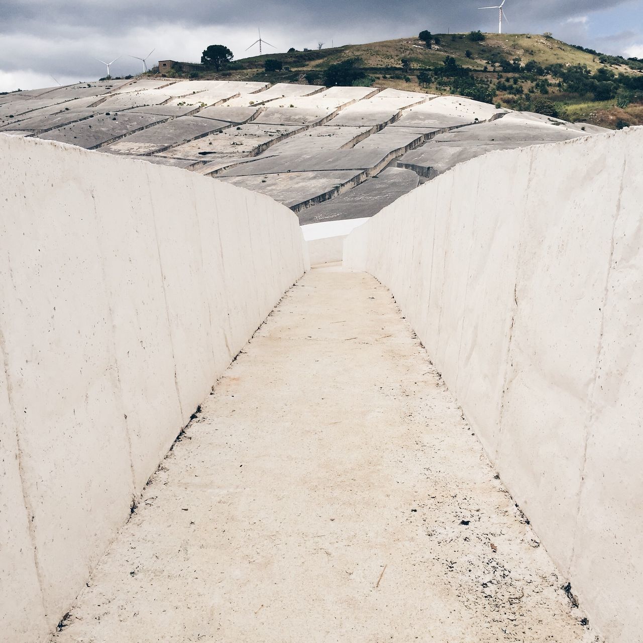 the way forward, diminishing perspective, vanishing point, built structure, architecture, sky, sand, sunlight, empty, road, day, tranquility, long, shadow, leading, tranquil scene, outdoors, beach, building exterior, in a row