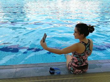 Young woman looking at swimming pool