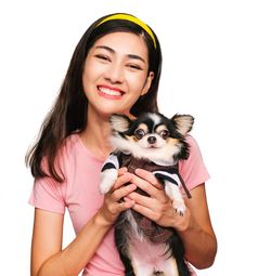 Portrait of a smiling young woman with dog against white background