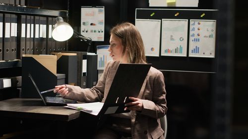 Rear view of woman using digital tablet in office