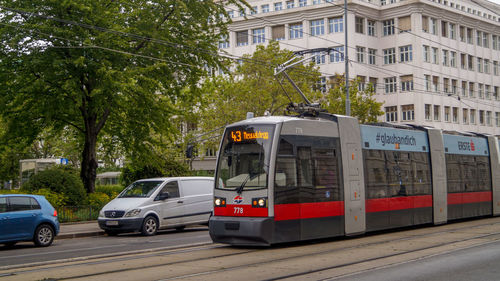 Cars on road by buildings in city