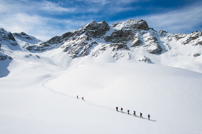 Group of people skiing on snowcapped mountain