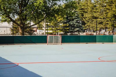 A view a goal of an unoccupied roller hockey rink in a city park