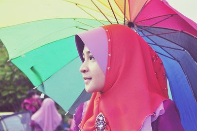 Side view of woman in hijab while holding umbrella