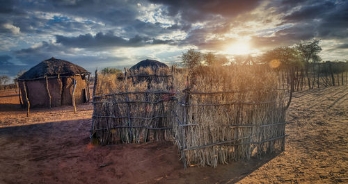 Fence on field against sky during sunset