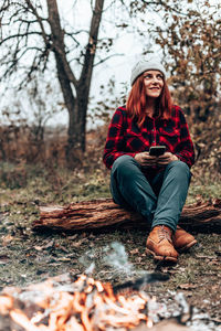 Portrait of young woman sitting on field