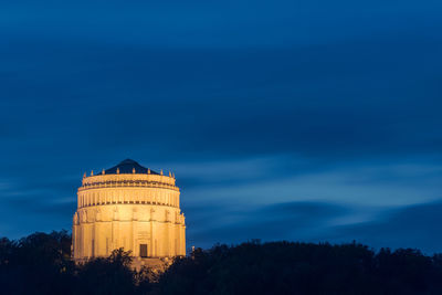 Low angle view of illuminated building against sky at dusk