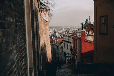 People on steps amidst buildings in city