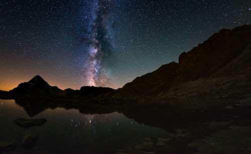 Scenic view of silhouette mountains against sky at night