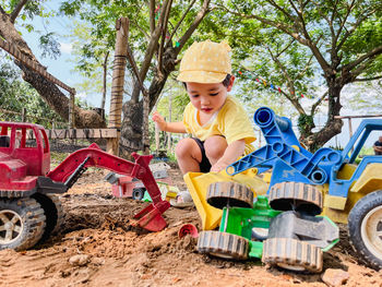 Asian boy, 2 years old, playing with old toys happily playing on the ground. on weekends of the week