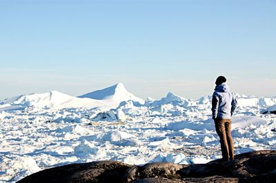 Lonely tourist looking at arctic landscape