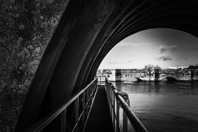 Bridge over river in city against sky