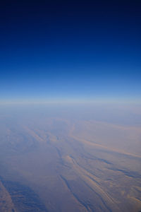 Aerial view of landscape against clear blue sky