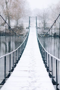 Rear view of man walking on footbridge