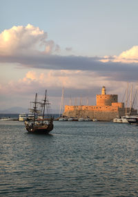 Boats in sea against sky during sunset