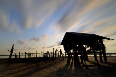 Silhouette people on pier against sky during sunset