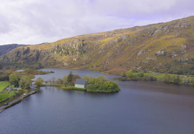 Scenic view of lake by mountain against sky