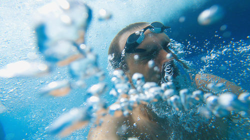 Snorkelling in the sea. a man with goggles on his head in the water among many bubbles