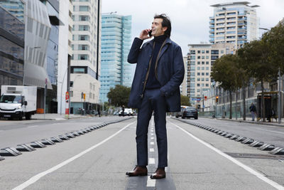 Portrait of businessman standing on road in city