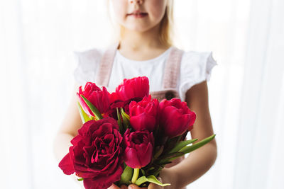 Close-up of woman holding red rose