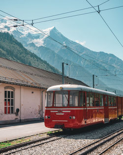 Train on railroad track by mountain against sky