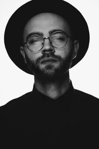 Portrait of young man wearing eyeglasses against white background