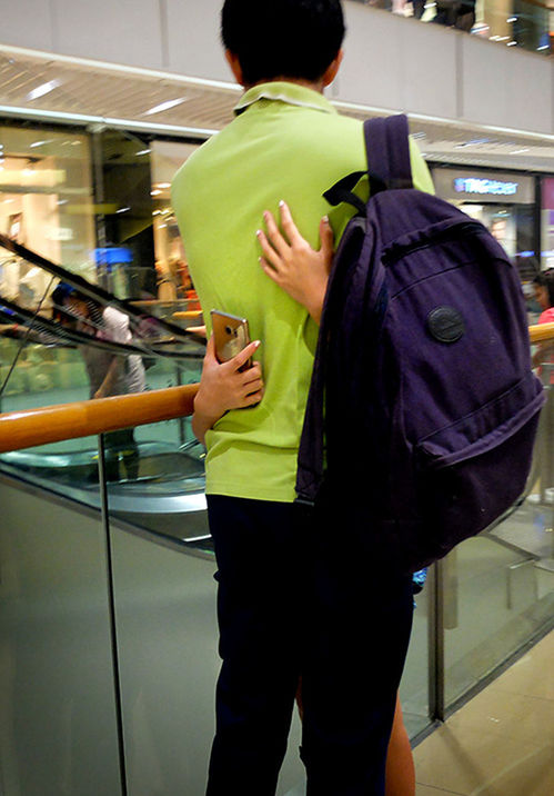 REAR VIEW OF YOUNG WOMAN STANDING BY SUBWAY STATION