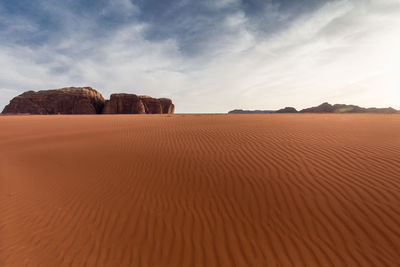 Sand dune in desert against sky