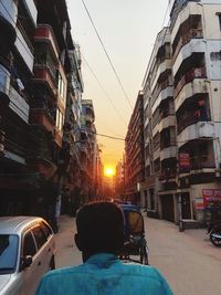 Rear view of man on street against buildings in city