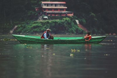 People in boat on river against sky